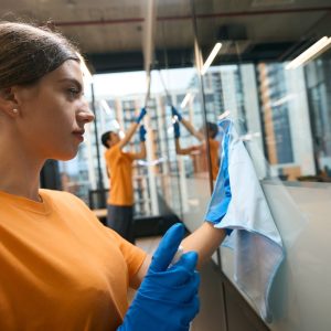 Cleaning service employees use a special glass scraper, special napkins